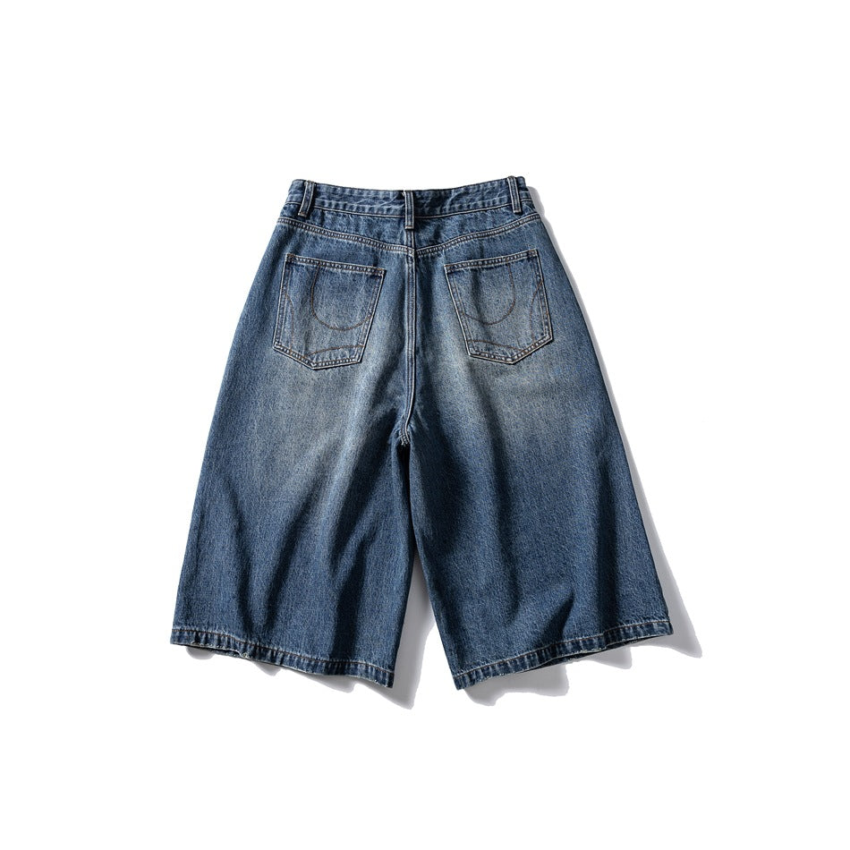 Back of washed blue wide-leg denim shorts with two patch pockets and contrast stitching