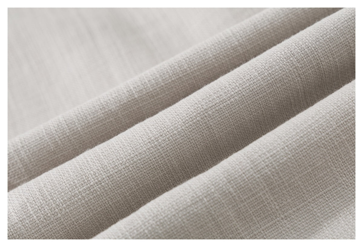 Macro view of the light beige shirt's coarse woven fabric texture.