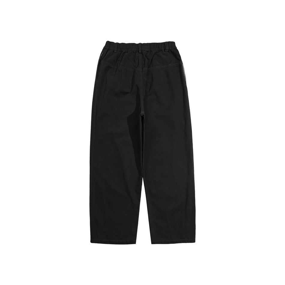 Front view of black wide-leg pants with an elastic waist, belt loops, and angled pockets on a white background.