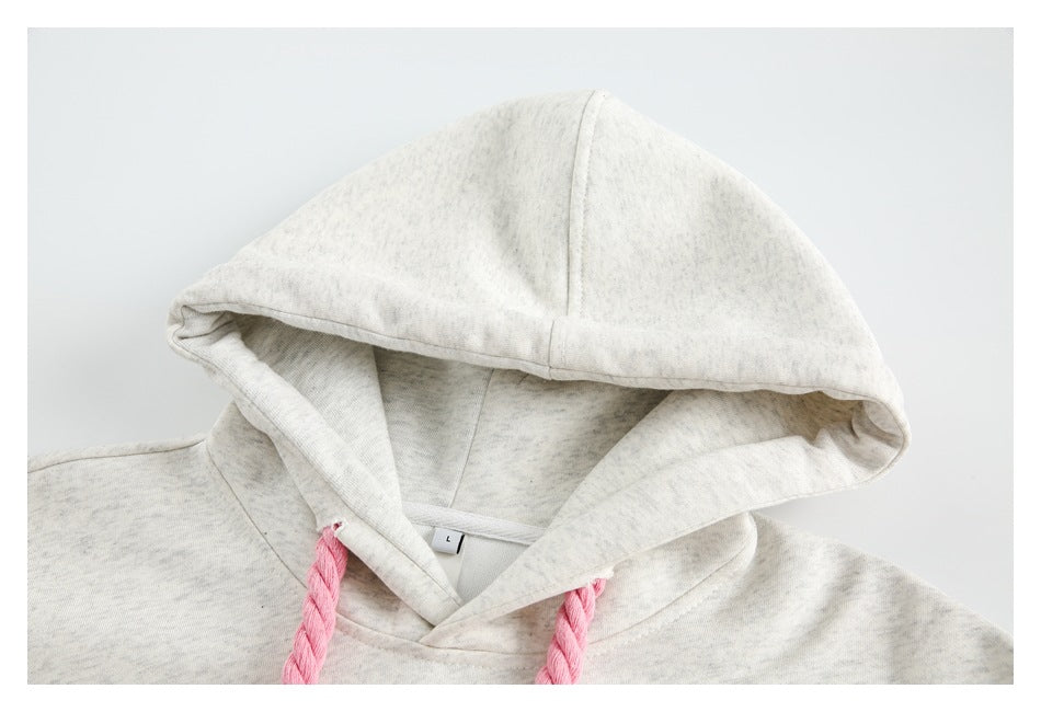 Close-up of a light heather gray hoodie hood, neckline and pink braided drawstrings; size tag reads L.