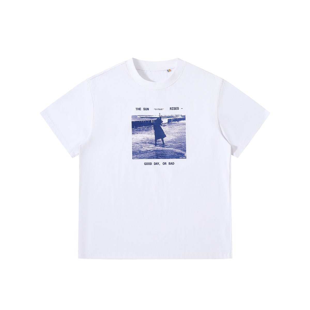 White short-sleeve crew neck t-shirt with blue beach photo print and 'The Sun Rises - Good Day, Or Bad' text, front flat lay