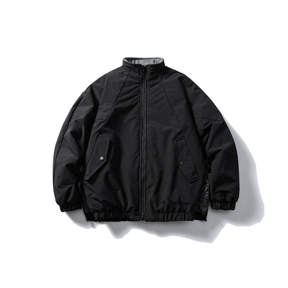 Front view of a black zip-front jacket with a stand collar, angled snap-flap pockets, and gathered cuffs and hem.