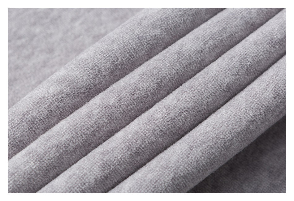 Close-up of heather-gray fabric draped in folds, showing its surface texture.