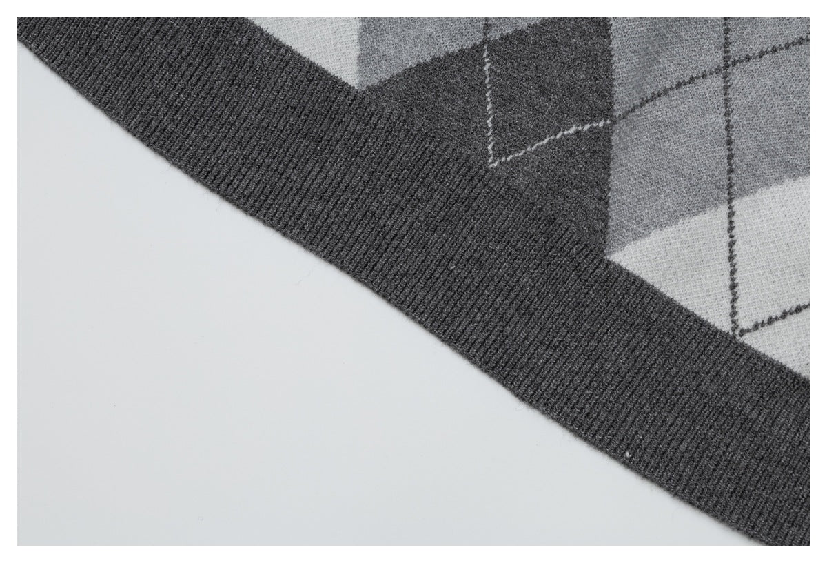 Close-up of the dark gray ribbed hem and gray argyle pattern of a cardigan.