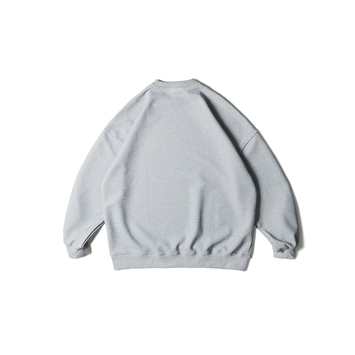 Back view of a plain light gray crewneck sweatshirt with dropped shoulders and ribbed cuffs and hem.