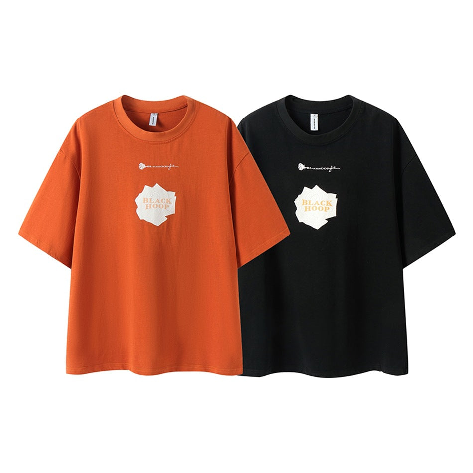 Orange and black short-sleeve crew-neck T-shirts shown from the front, each with a white chest graphic.