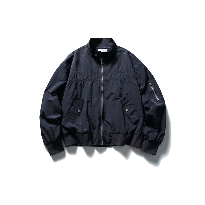 Navy stand-collar zip jacket flat lay with chest gathering, flap pockets and ribbed hem