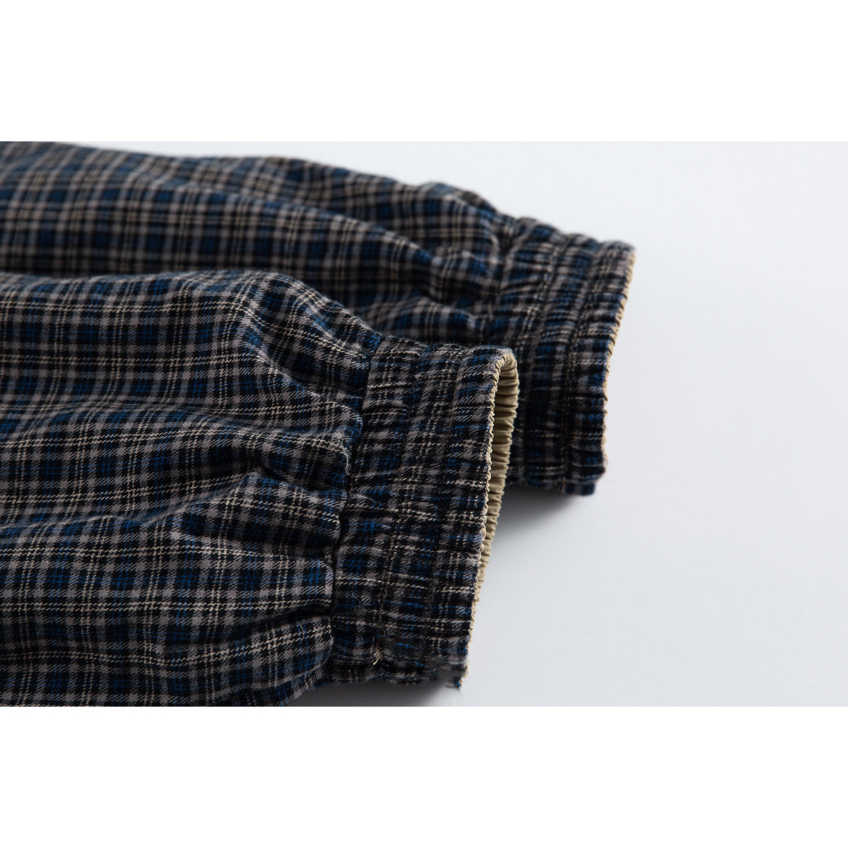 Close-up of the jacket's plaid sleeve and gathered elastic cuff, with beige lining visible at the edge.