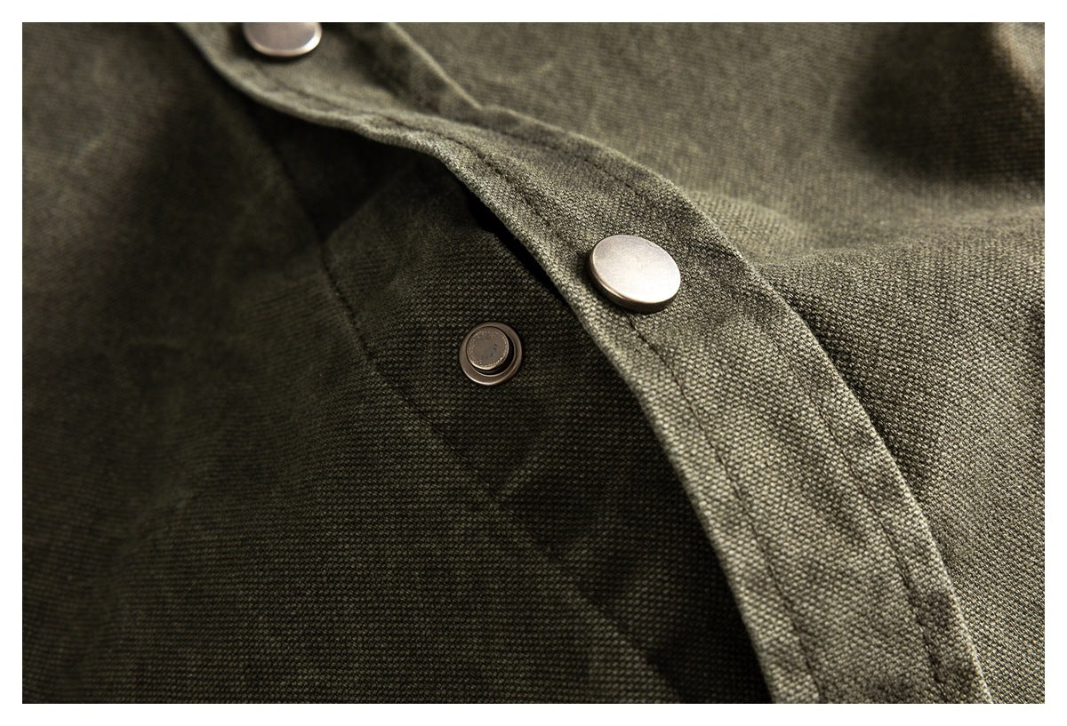 Close-up showing the olive-gray shirt's metal snap closure and textured fabric.
