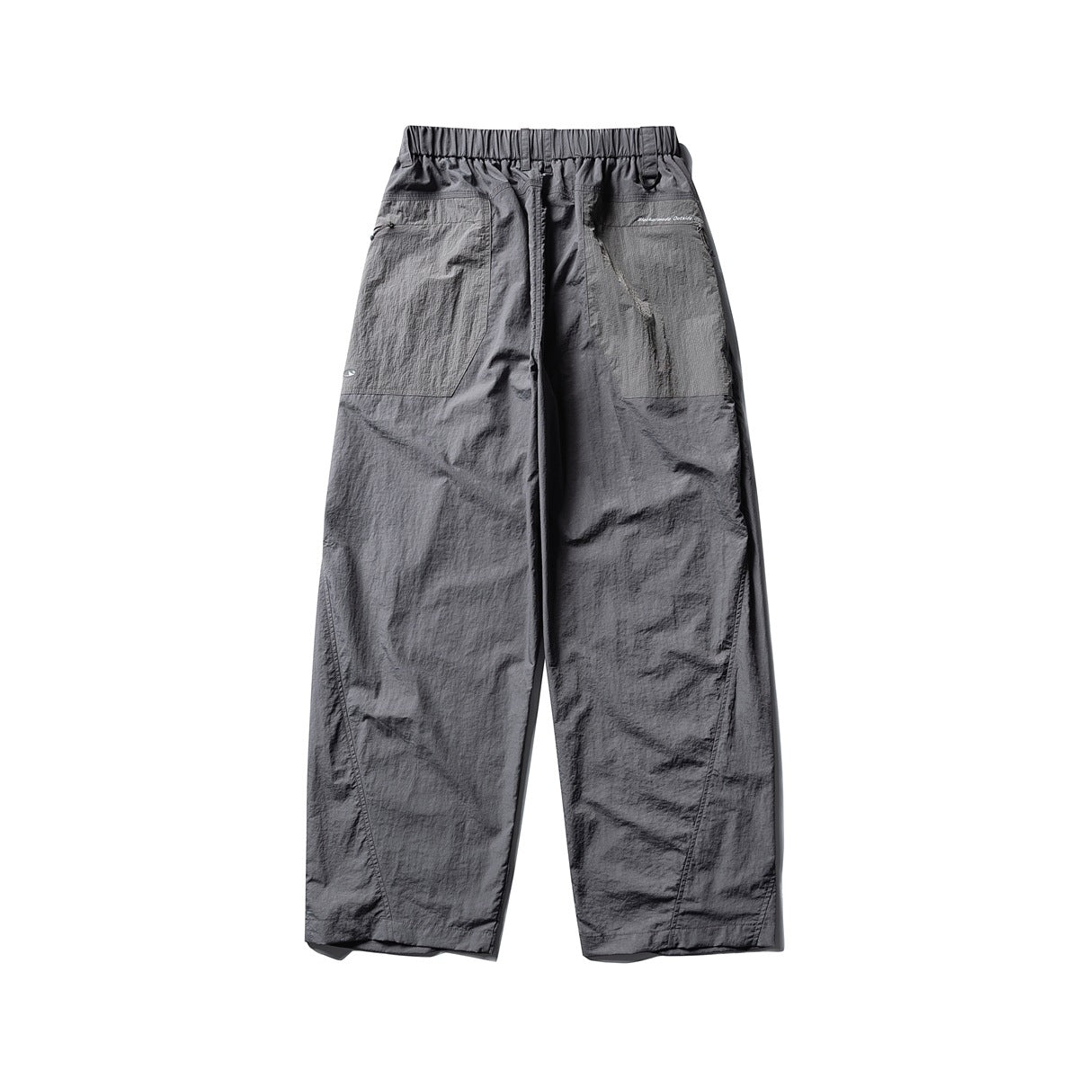 Rear view of loose charcoal-gray pants with a gathered waistband and two large patch pockets.