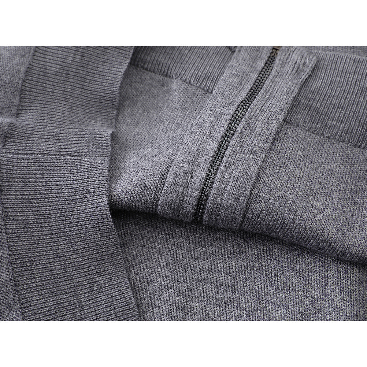 Close-up of gray knit jacket fabric, ribbed cuff, and zipper details.