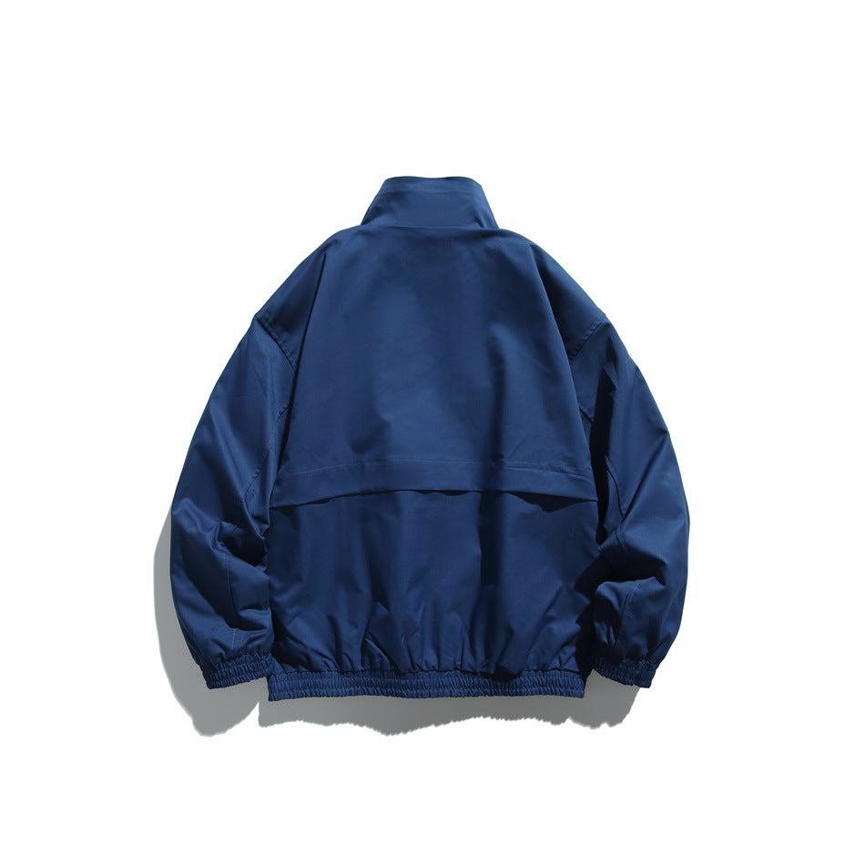 Back view of a navy jacket with a horizontal upper-back flap, stand collar, and elastic cuffs and hem.