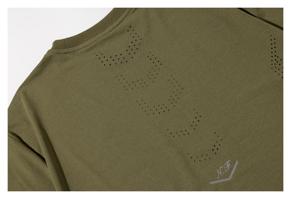 Close-up of an olive-green crewneck garment with dotted perforation patterns and a small N.J. print.