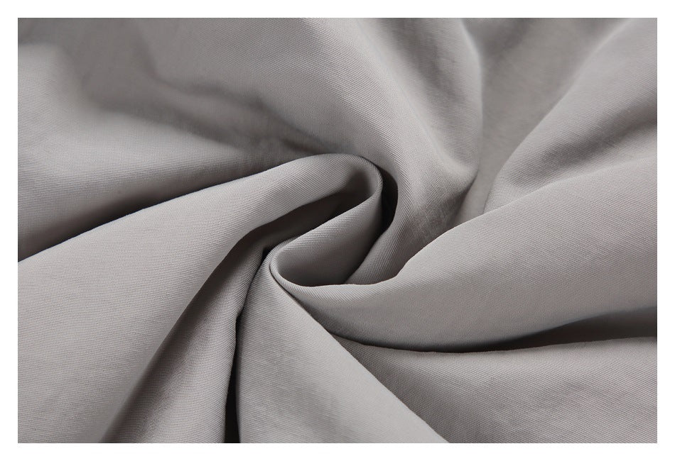 Close-up of light gray fabric gathered into soft folds.