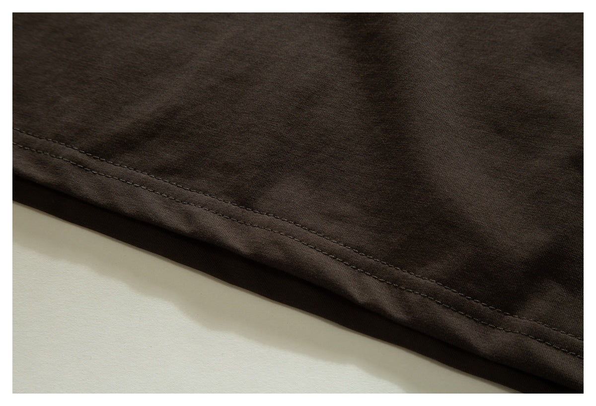 Close-up of the stitched hem on dark brown fabric.