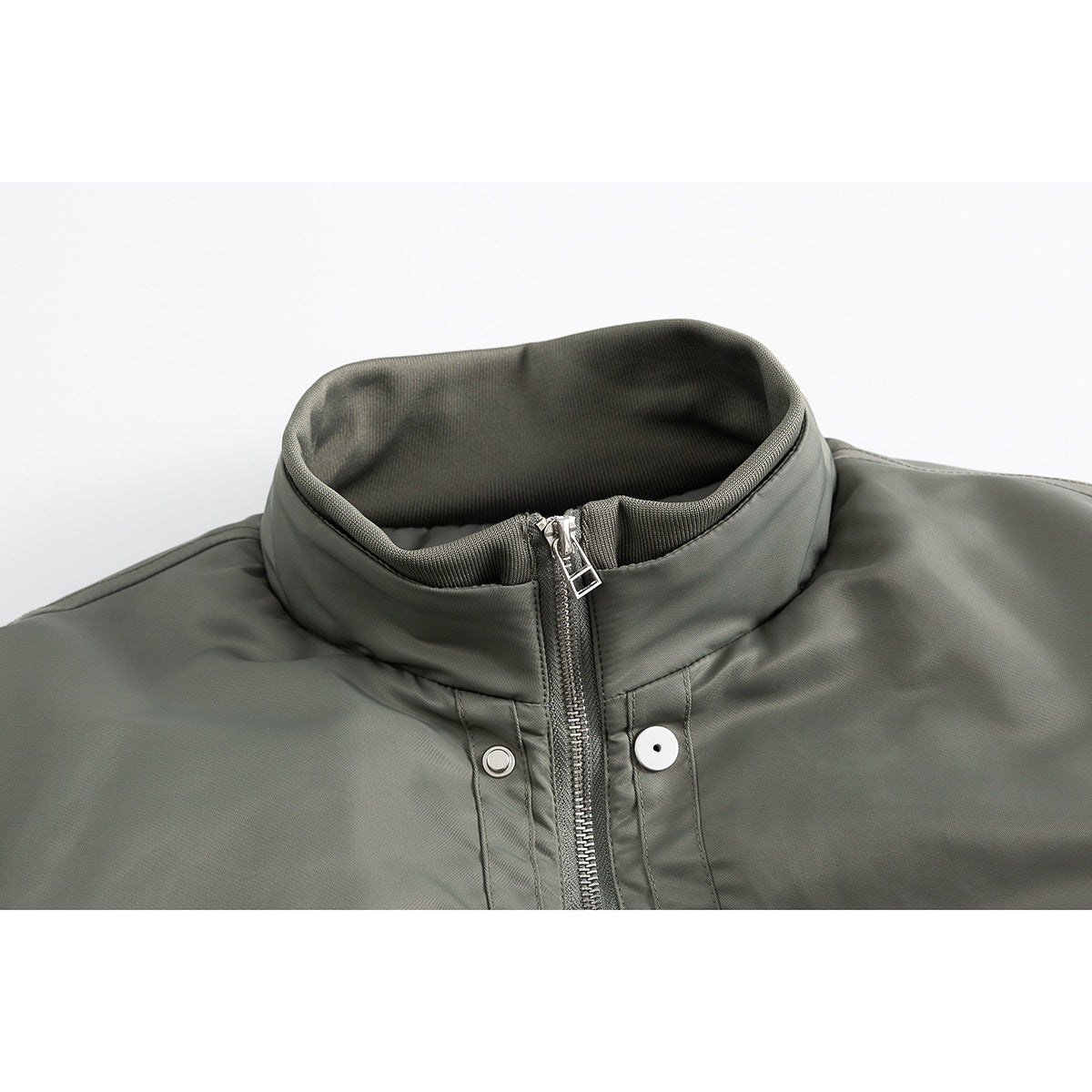 Close-up of an olive-gray jacket's stand collar, front zipper, and snap-button placket.