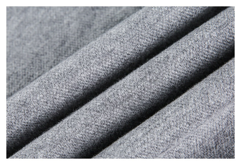 Close-up of heather gray knit fabric arranged in diagonal folds, showing its fine textured surface.