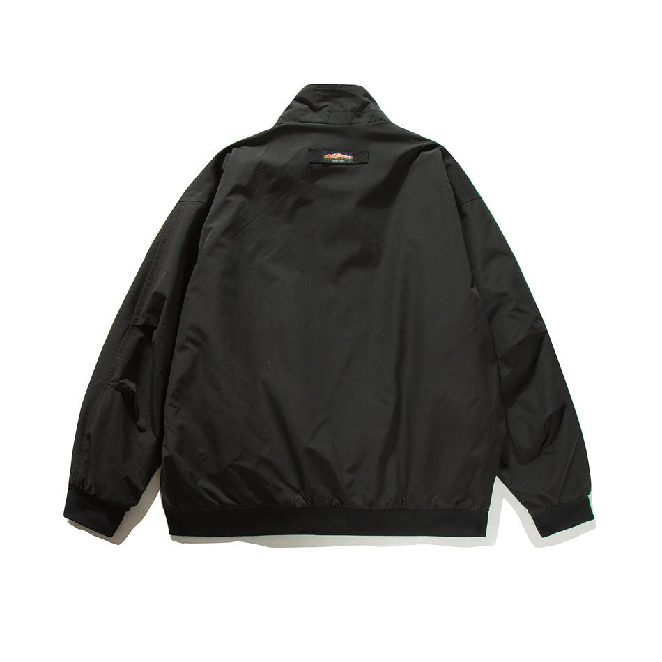 Back view of a black stand-collar jacket with elastic cuffs and hem and a small upper-back patch.