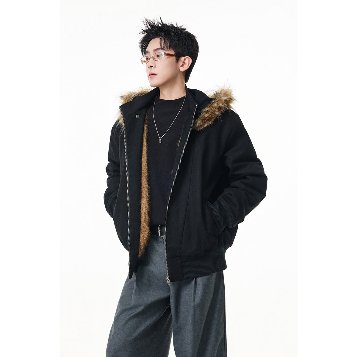 Model wearing an open black hooded jacket with brown faux-fur trim, ribbed cuffs and hem, over dark clothing.