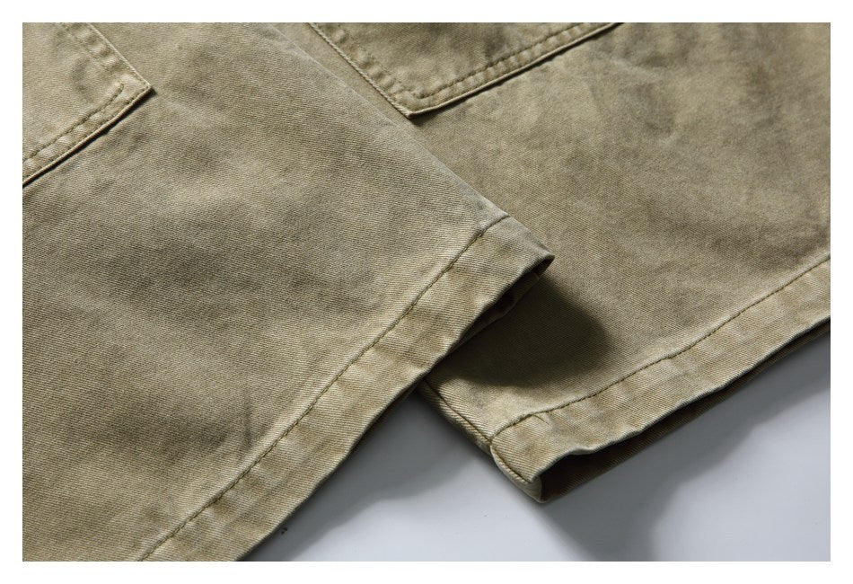 Close-up of khaki trousers showing stitched hems and faded, mottled coloring.