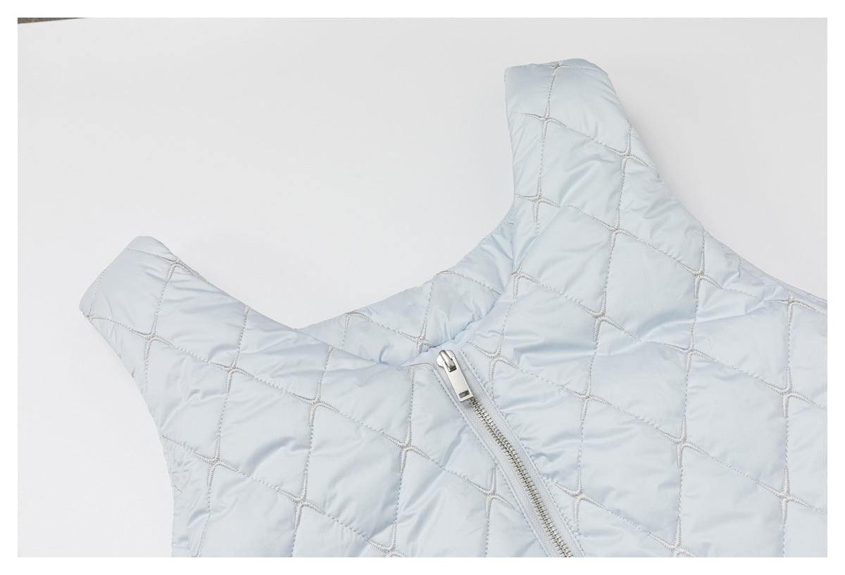 Close-up of a pale blue quilted garment neckline and shoulder with a silver zipper.