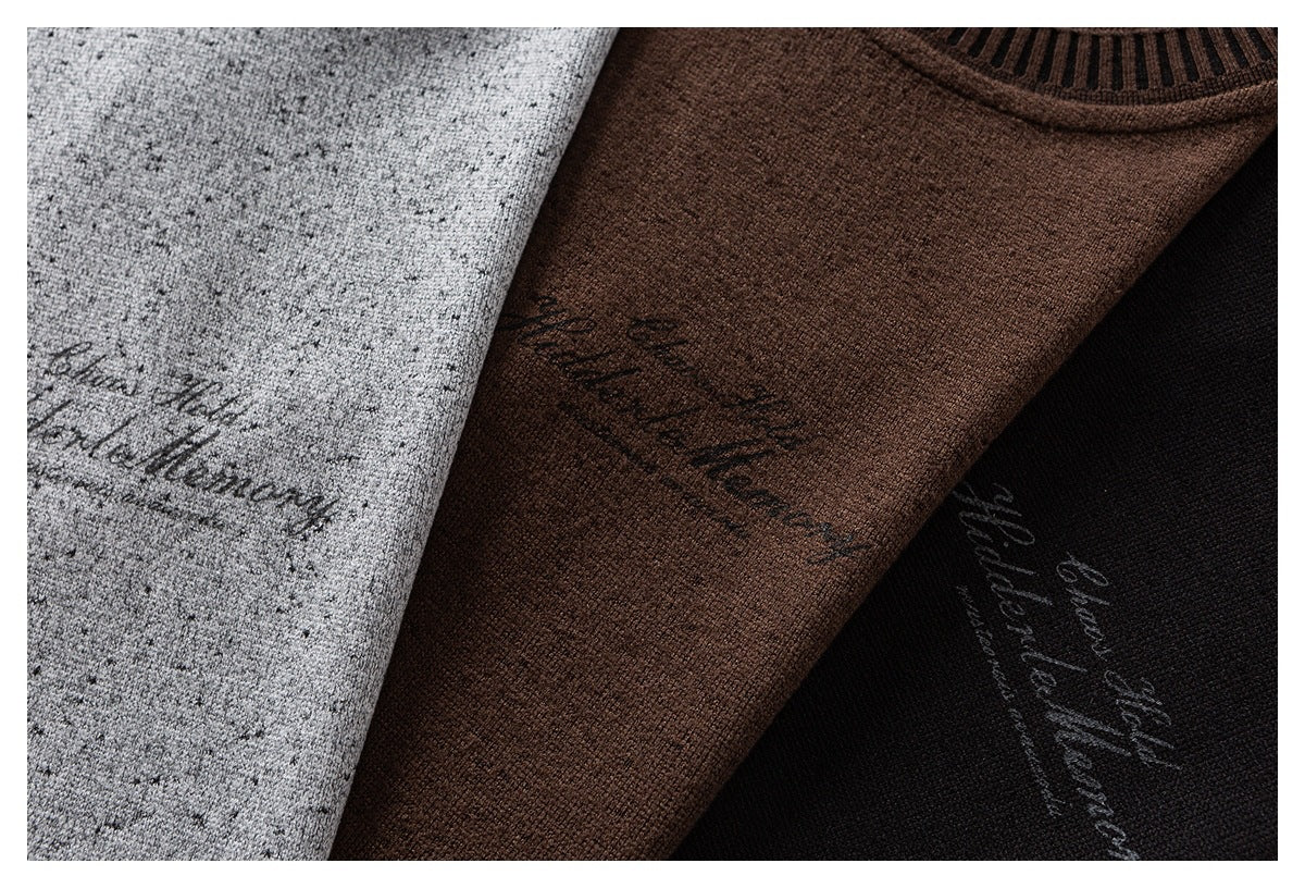 Close-up of gray, brown, and black sweaters with flecked knit texture and script lettering.