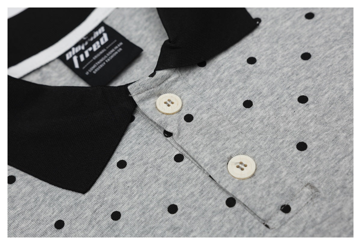 Close-up of the gray dotted shirt's black collar and placket with two cream buttons.