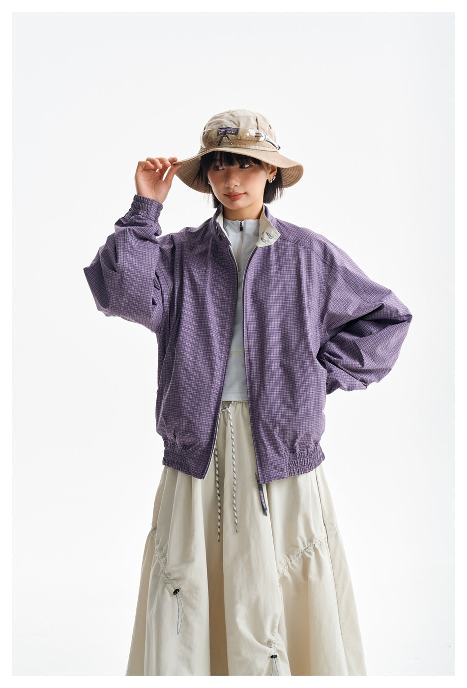 Front view of a model wearing a purple plaid jacket with a pale contrasting collar.