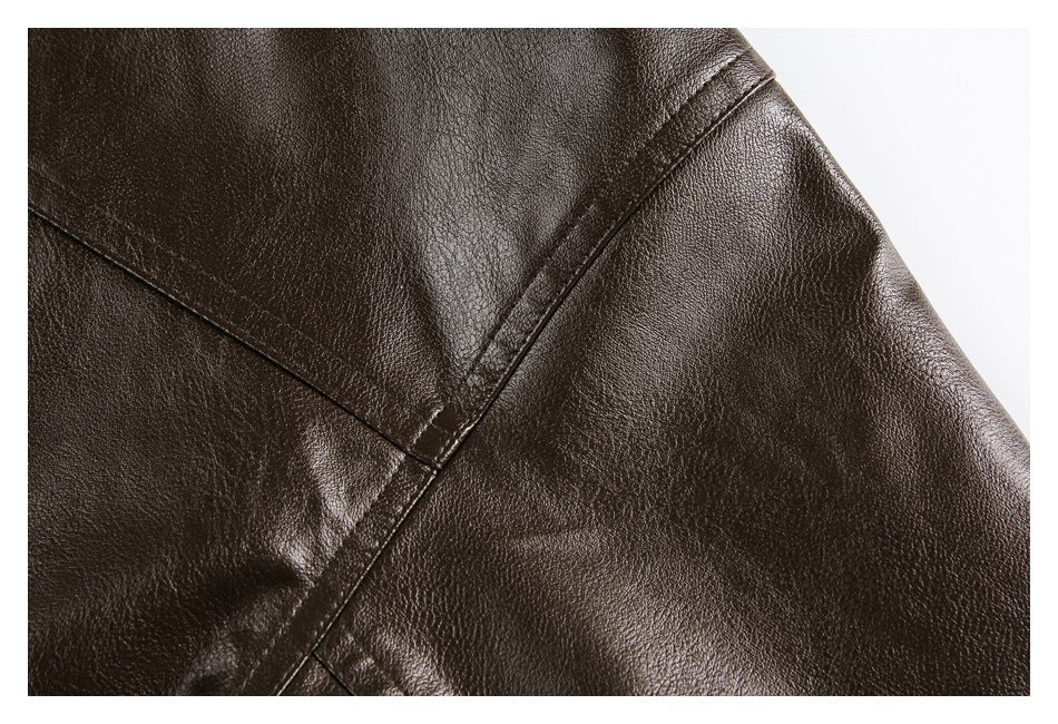 Close-up of dark brown pebbled material showing intersecting stitched seams and a glossy finish.