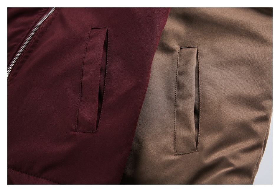 Close-up of burgundy and taupe jacket fronts showing vertical pockets and a silver zipper.