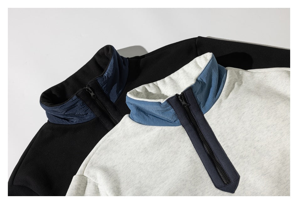 Close-up of gray and black pullovers showing contrasting stand collars and quarter zippers.
