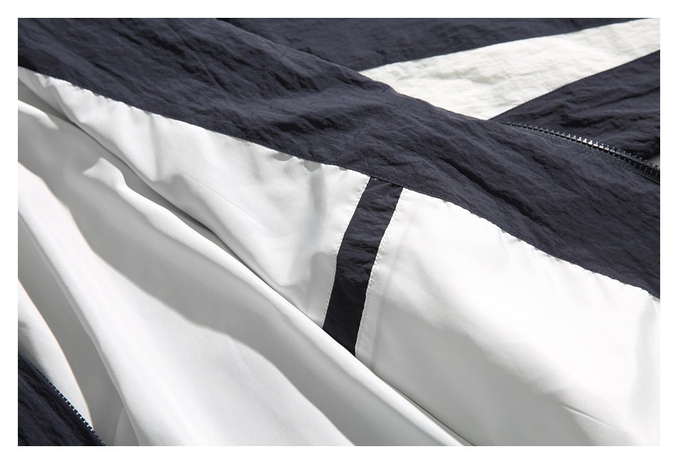 Close-up of a dark navy garment interior with white lining, a zipper, and a contrasting strip.