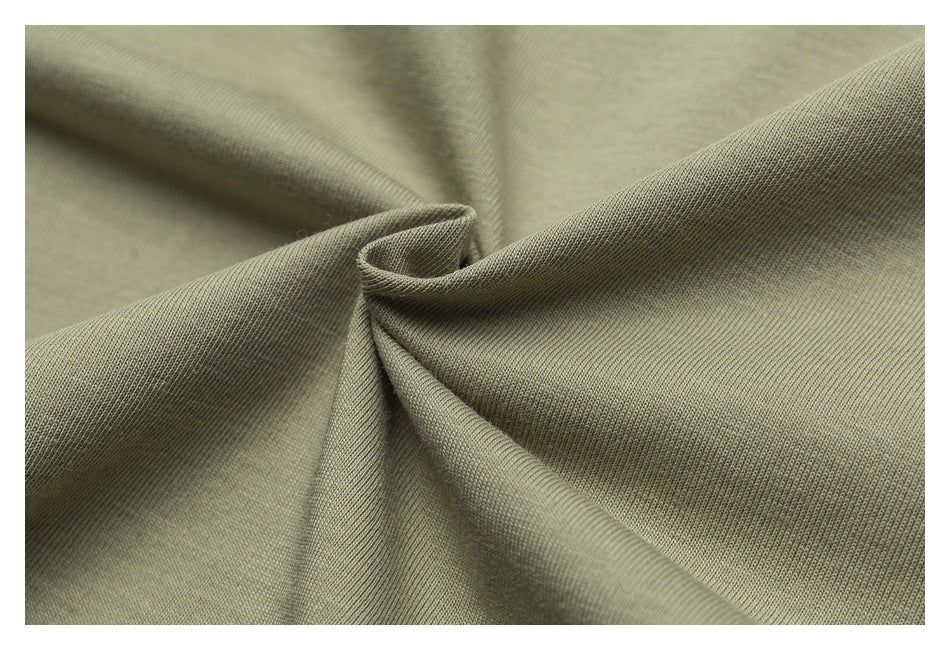 Close-up of olive-green fabric gathered into soft folds, showing its surface texture.