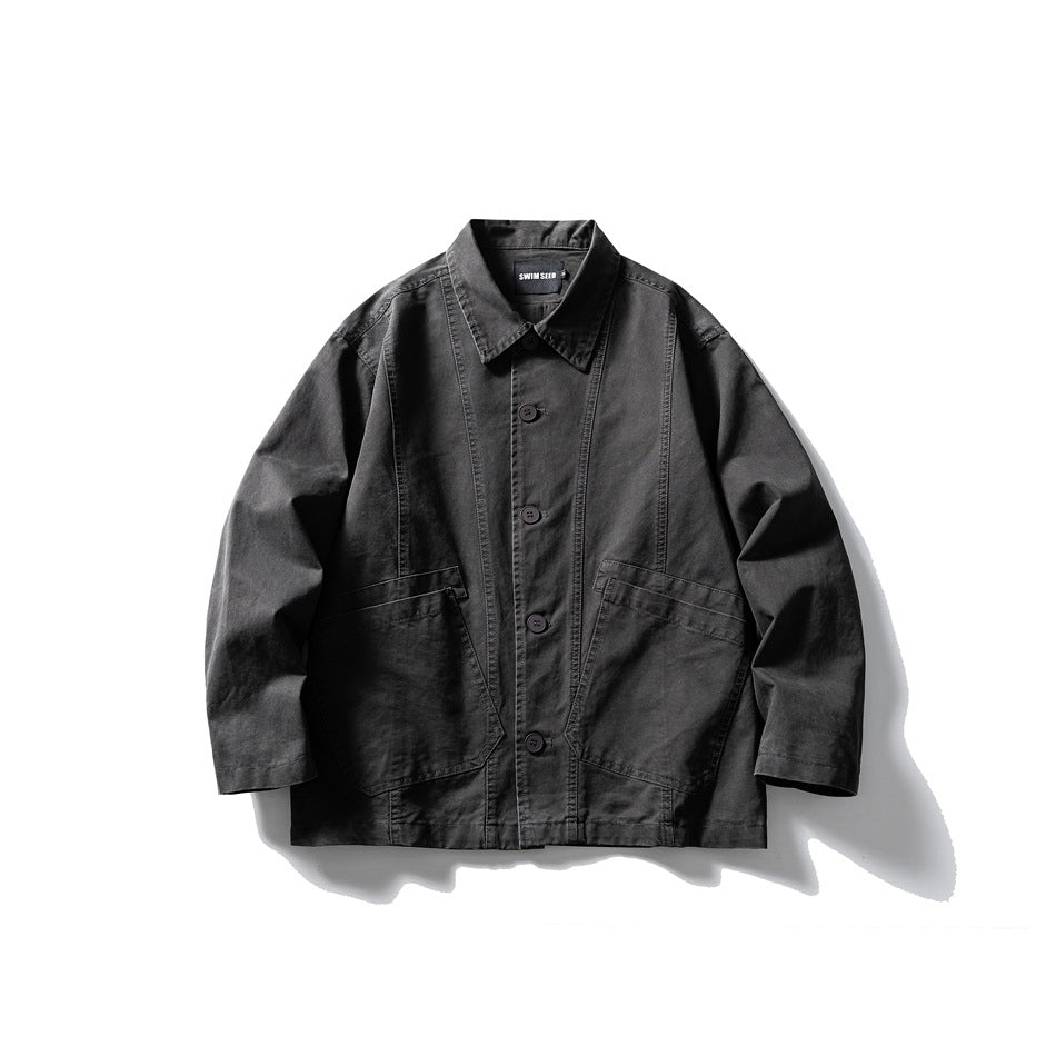 Dark grey button-front work jacket with pointed collar, paneled seams and two large patch pockets, flat lay front view