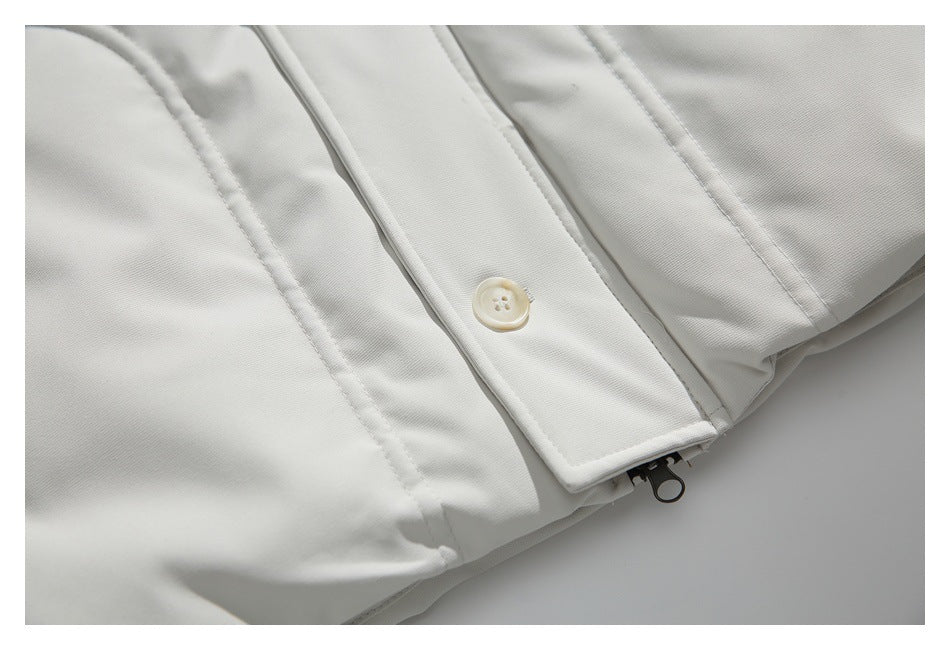 Close-up of an ivory jacket's button placket, curved seam, and zipper pull.