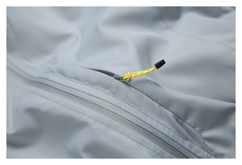 Close-up of a gray jacket zipper and bright yellow cord pull with a black end cap.