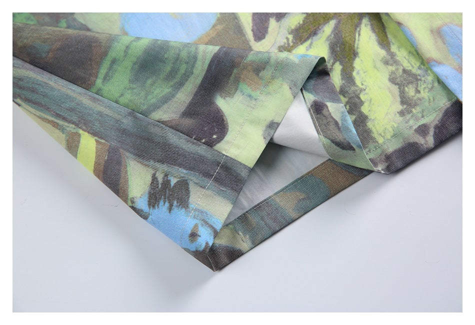 Close-up of the shirt's folded lower hem and stitched edge in a multicolored abstract print.