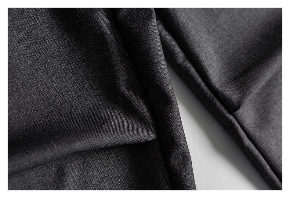 Close-up of charcoal gray trouser fabric and folded seams.