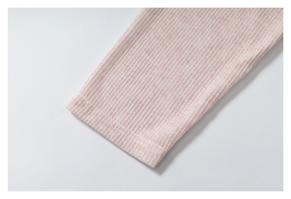 Close-up of a pale pink ribbed sleeve and its hem.