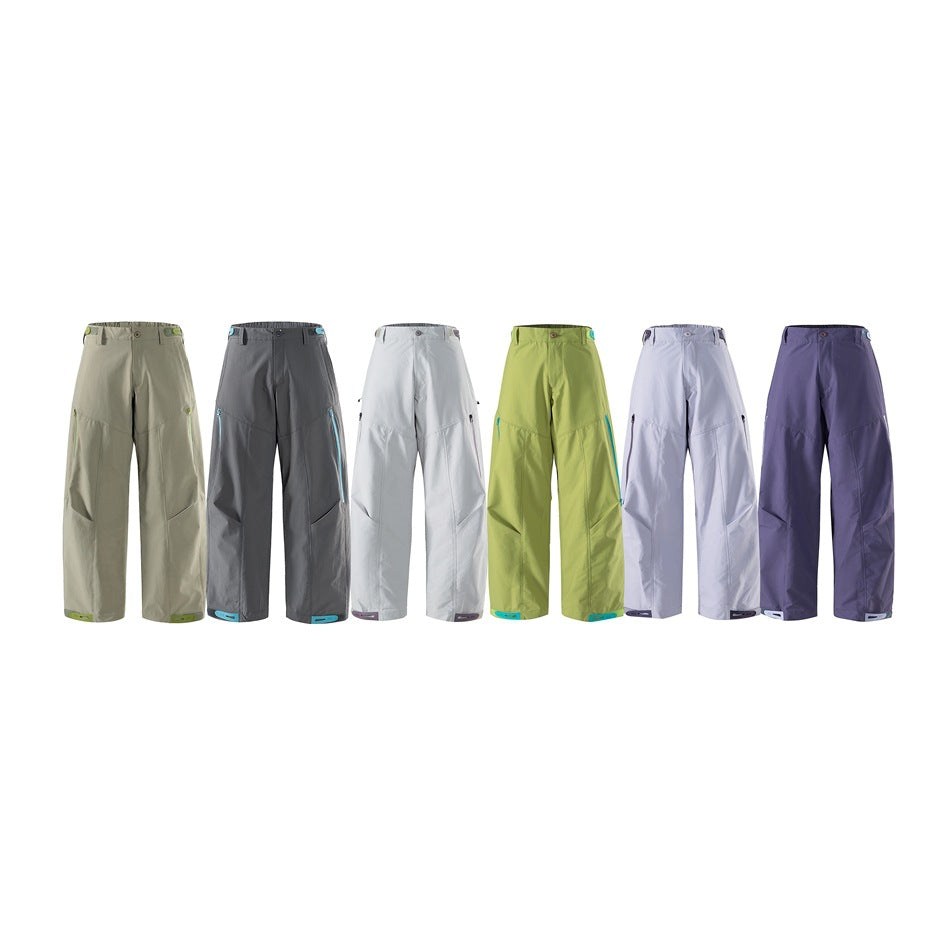 Six pairs of loose cargo pants shown side by side in muted green, charcoal, white, lime, pale lavender, and purple.