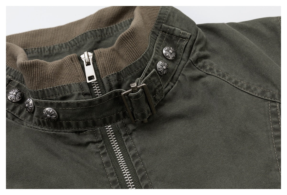 Close-up of the olive-gray jacket collar with a brown ribbed insert, metal zipper, buckle strap, and floral buttons.