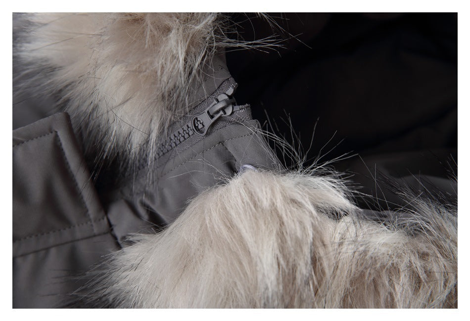 Close-up of a dark gray jacket zipper beside long pale gray fur trim.