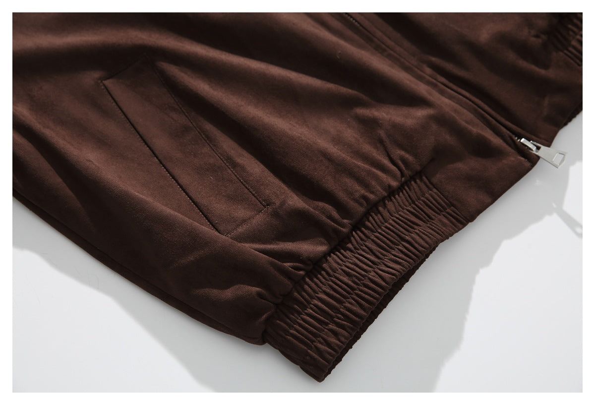 Close view of the jacket's angled front pocket, center zipper and gathered elastic hem.