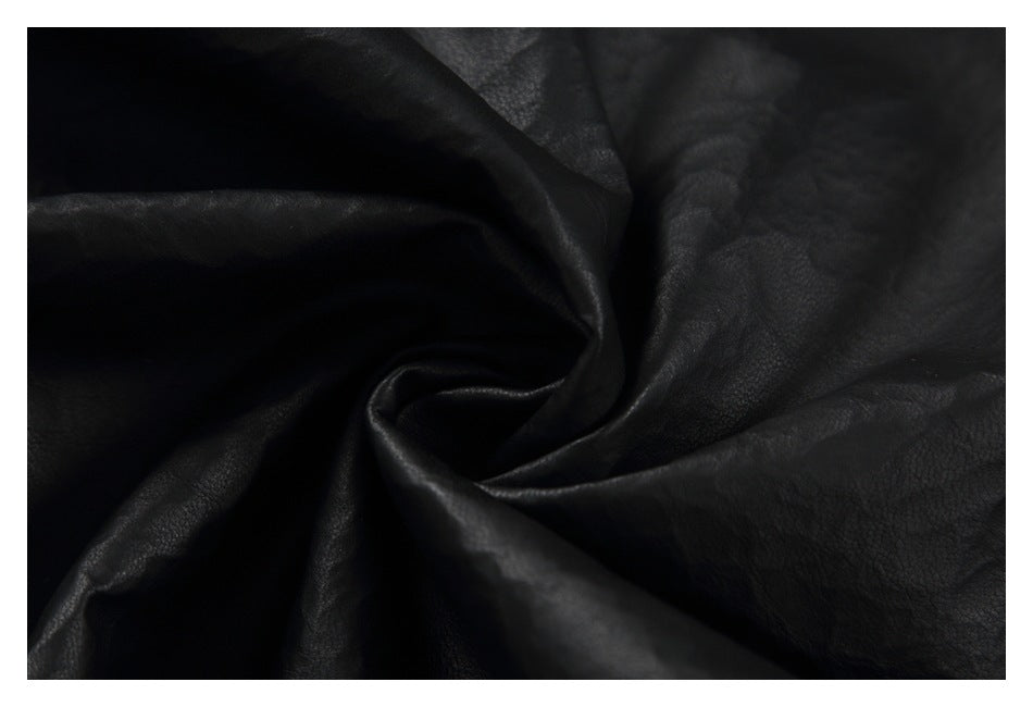 Close-up of black textured material draped in soft folds.