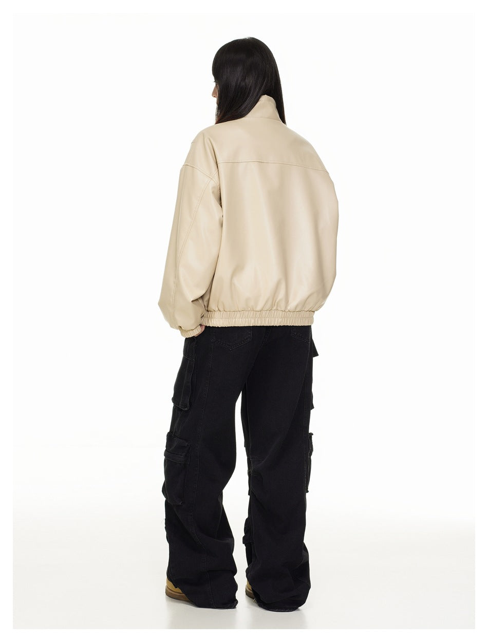 Rear view of a model wearing a beige oversized jacket with a high collar and elasticated hem and cuffs.