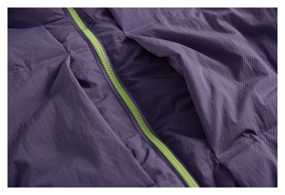 Close-up of the purple jacket's lime-green zipper and textured quilted outer fabric.