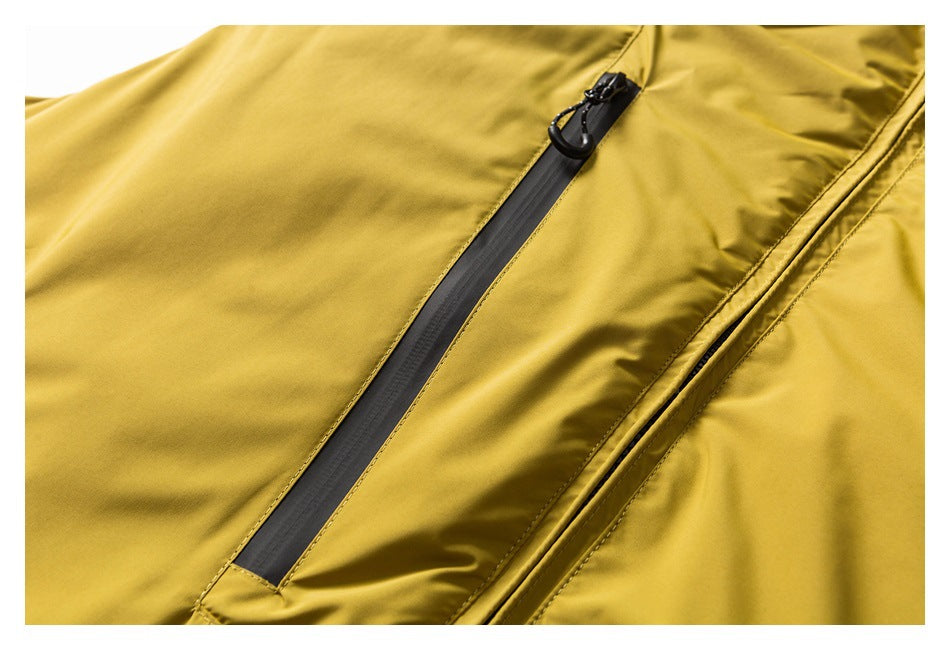 Close-up of a black zipper and pull on mustard-yellow garment fabric.