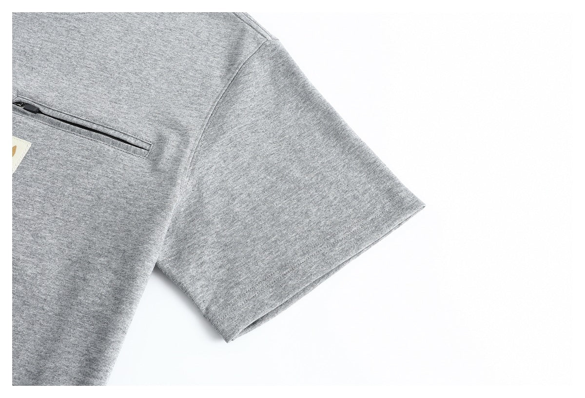 Close-up of the heather gray T-shirt's short sleeve and stitched hem, with part of the chest pocket visible.