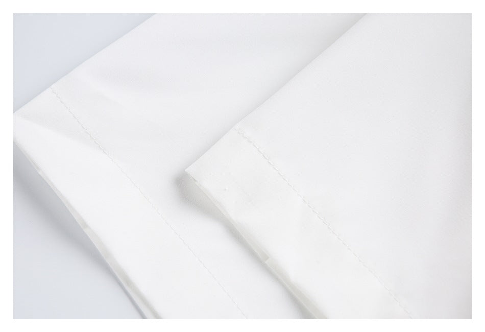Close-up of stitched hems on two overlapping sections of white fabric.