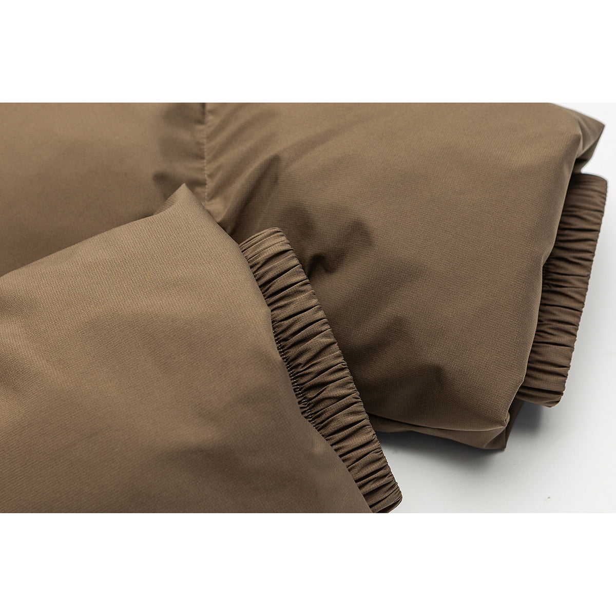 Close-up of the brown jacket fabric and gathered elastic cuff.